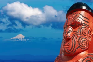 Tradizionale scultura maori su sfondo Taranaki Mount, Nuova Zelanda