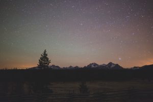 Stars and colored night sky over mountains near Stanley, Idaho, USA.
