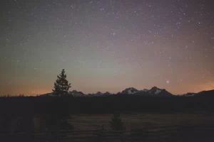 Stars and colored night sky over mountains near Stanley, Idaho, USA.