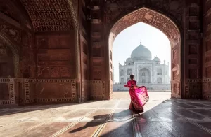 Donna in rosso saree/sari nel Taj Mahal, Agra, Uttar Pradesh, India