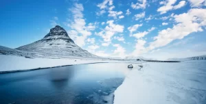 Winter landscape with rising sun on Kirkjufellsfoss waterfall and Kirkjufell mountain, Iceland, Europe.
