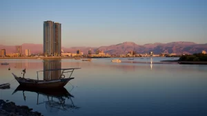 Ras Al Khaimah City in the United Arab Emirates in the evening sunset at the Corniche with the crisp clear purple colored mountain view towards Jebal Jais in the Hajar Mountains.