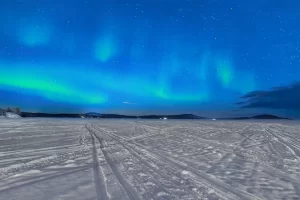 Northern lights glow above a frozen lake inari in Lapland