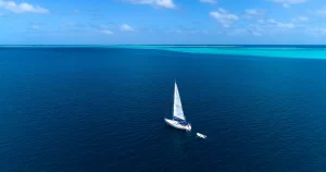 sailboat in aerial view with bungalow in background, French Polynesia