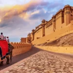 I turisti godono di un elefante a Amer Fort Jaipur Rajasthan al tramonto.