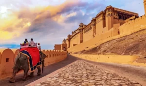 I turisti godono di un elefante a Amer Fort Jaipur Rajasthan al tramonto.