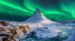 l'aurora boreale appare sopra il monte Kirkjufell in Islanda.