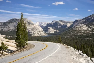Scenic Tioga Pass road running through Sierra Nevada mountain scenery on sunny day in summer at Olmsted Point in Yosemite National Park.