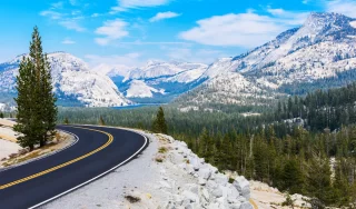 Scenic Tioga Pass road running through Sierra Nevada mountain scenery on sunny day in summer at Olmsted Point in Yosemite National Park.