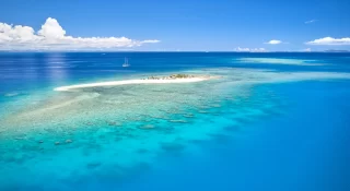 Remote island in Fiji overlooking blue coral reef