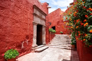 Narrow street with the arch of the monastery of Santa Catalina, Arequipa, Peru, potted flowers around