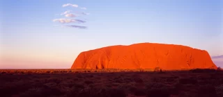aerial view of Uluru Rock in Australia illuminated by a stunning sunset