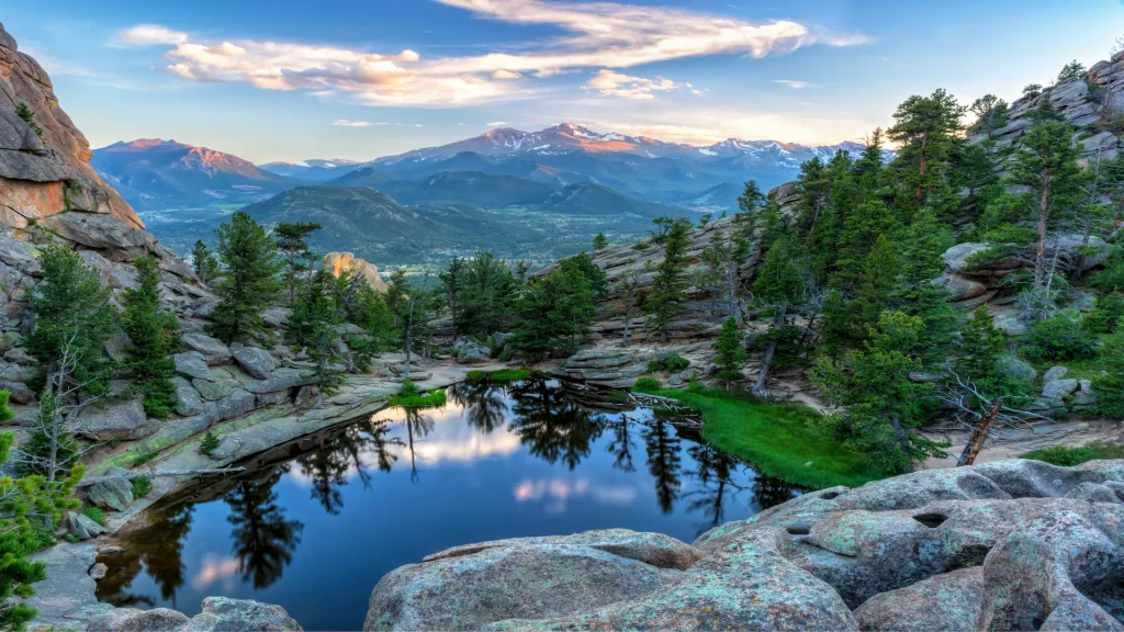 Il sole colpisce Longs Peak e The Crags sopra Gem Lake nel Parco Nazionale Rocky Mountains, Estes Park, Colorado | Tour Grandi Parchi USA, un'esclusiva Alidays | Da Denver a Salt Lake City