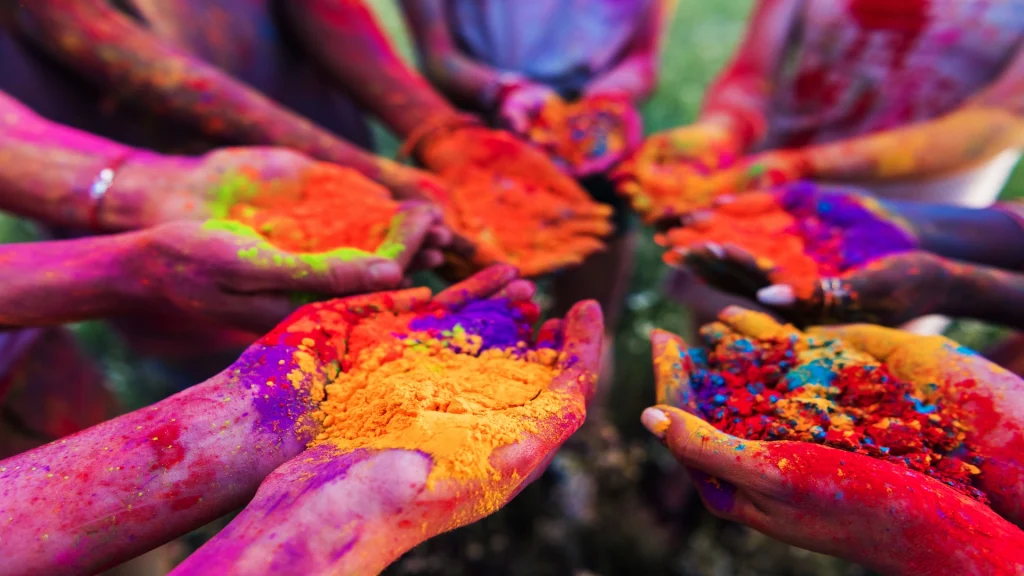 Primo piano mani dei giovani in possesso di polvere colorata nelle mani al festival holi | Tour Rajasthan Holi Festival: la festa dei colori | Alidays Travel Experience