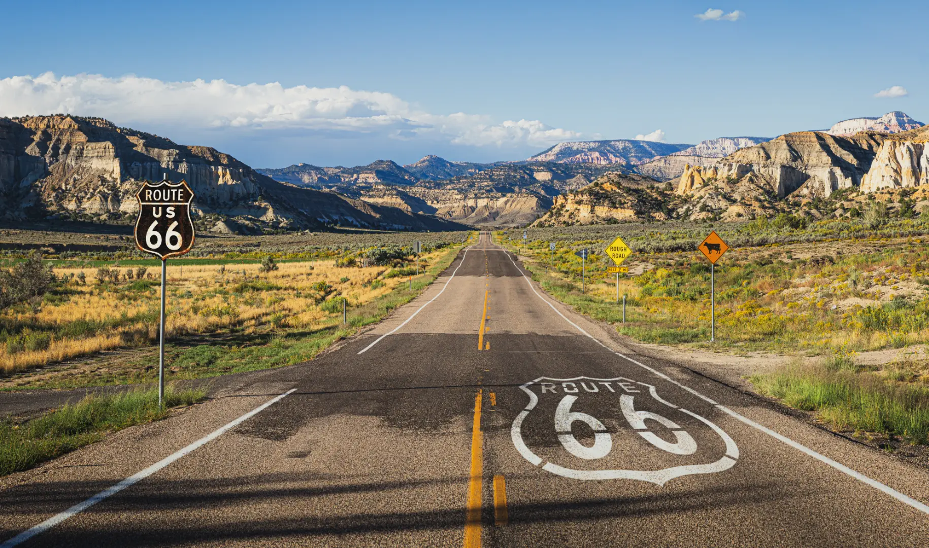 Vista panoramica della Route 66 con cartelli stradali al tramonto