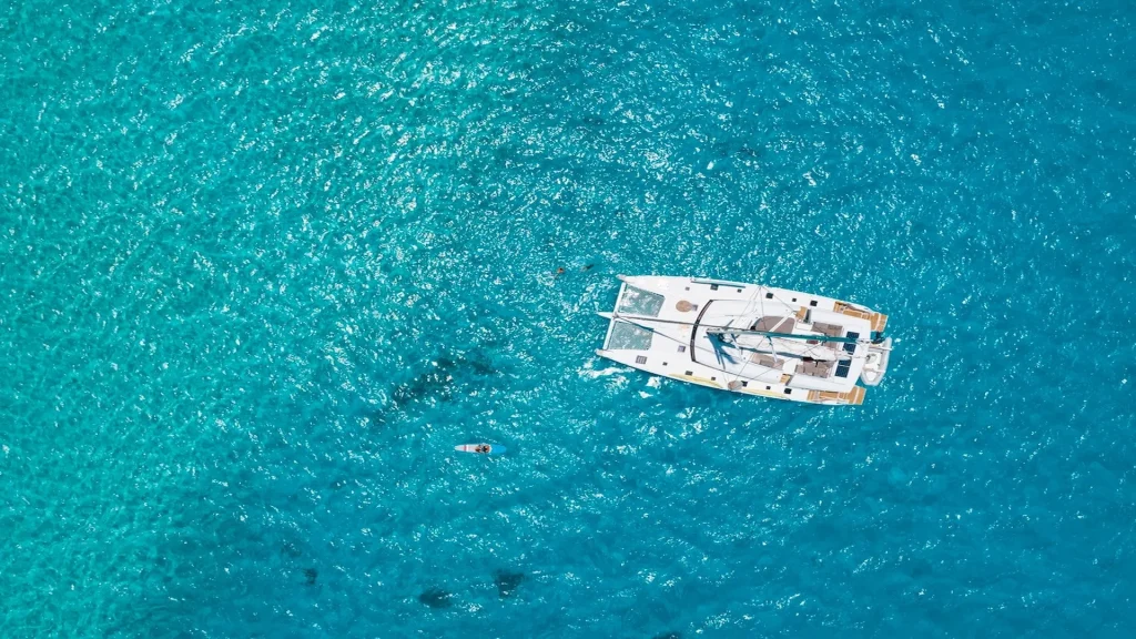 Vista dall'alto del mare della Polinesia Francese con catamarano | Organizza il tuo viaggio su misura in Polinesia con Alidays