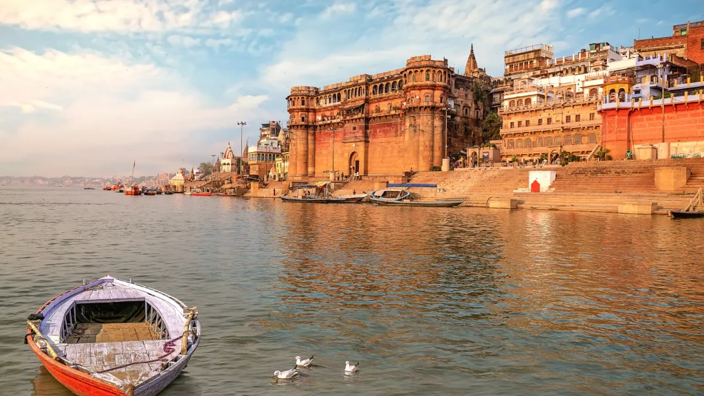 Antica architettura della città indiana di Varanasi con barca sul fiume Gange al tramonto | Tour Le voci del Rajasthan e Varanasi