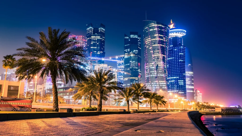 Vista notturna sul centro della città di Doha, Qatar, con molti moderni edifici di lusso e grattacieli illuminati