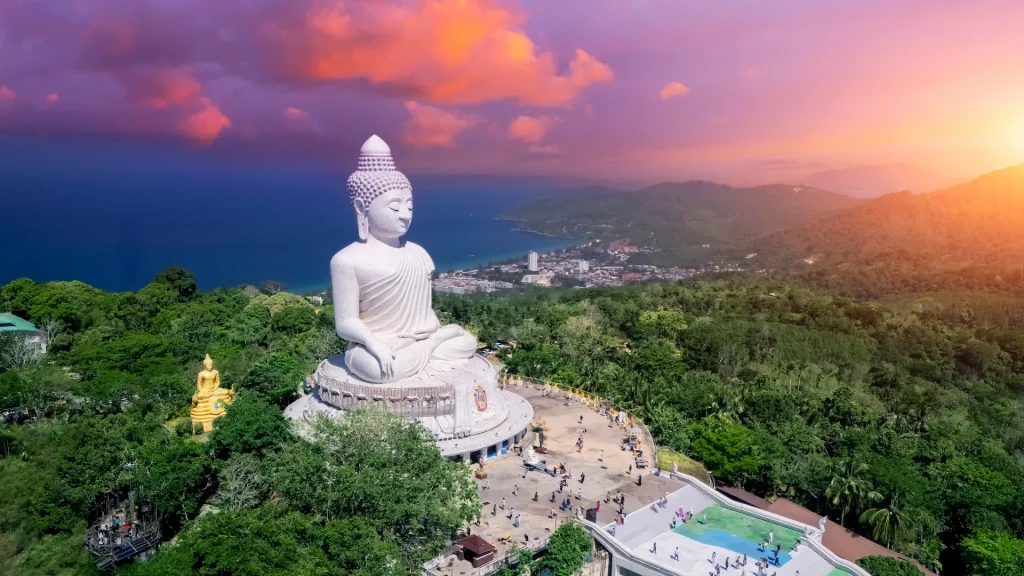 Scenario di paesaggio in cima aerea tramonto viola nuvole arancione cielo serale e oceano blu dietro Phuket bianco grande Buddha | Tour esclusivo Natale e Capodanno in Thailandia con soggiorno mare a Phuket | Esclusiva Alidays Travel Experience