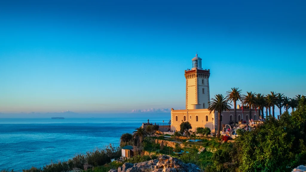 Faro di Cap Spartel al tramonto con palme e vista sull'oceano a Tangeri, in Marocco | Viaggio Marocco nord on the road: Il nord andaluso e le città dei sultani | Alidays