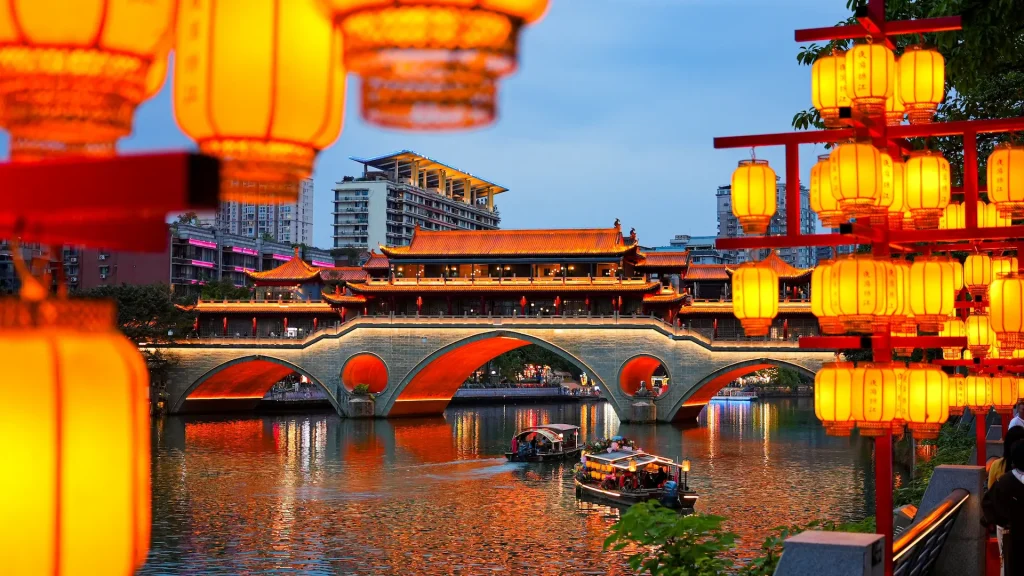 Ponte coperto Anshun illuminato al crepuscolo incorniciato da tradizionali lanterne rosse sul fiume Jin, Chengdu, Sichuan, Cina | Tour Cina 12 giorni: "La via dei secoli tra storia e natura" | Alidays