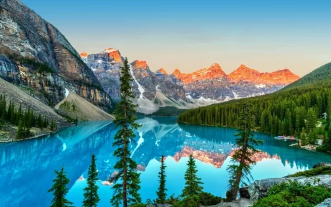 Golden sunrise over the Valley of the Ten Peaks with glacier-fed turquoise-colored Moraine Lake in the foreground near Lake Louise in the Canadian Rockies of Banff National Park.