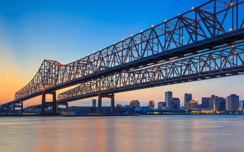 New Orleans, Louisiana, USA at Crescent City Connection Bridge over the Mississippi River at dusk.