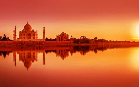 Vista panoramica del Taj Mahal durante il tramonto riflesso nel fiume Yamuna