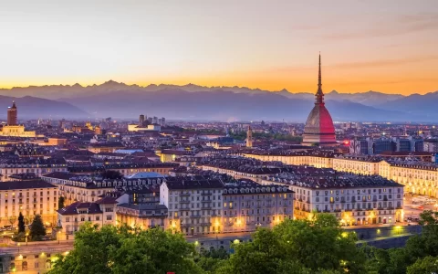 Torino al tramonto con cielo limpido e colorato. La Mole Antonelliana che domina la città.