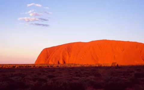 aerial view of Uluru Rock in Australia illuminated by a stunning sunset