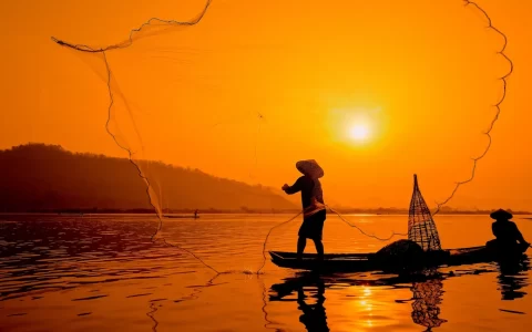barca da pesca nel fiume Mekong al sorgere del sole