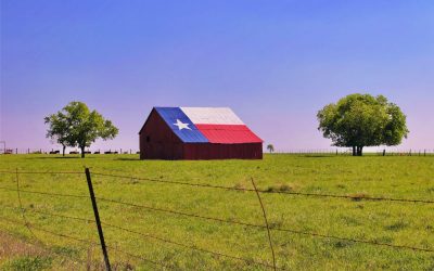 A barn in rural Texas with the state flag painted on the roof