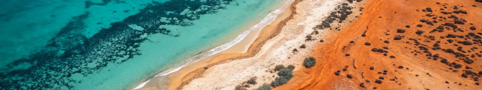 Vista aerea di un oceano turchese che incontra una spiaggia sabbiosa con dune rosse, Australia Occidentale