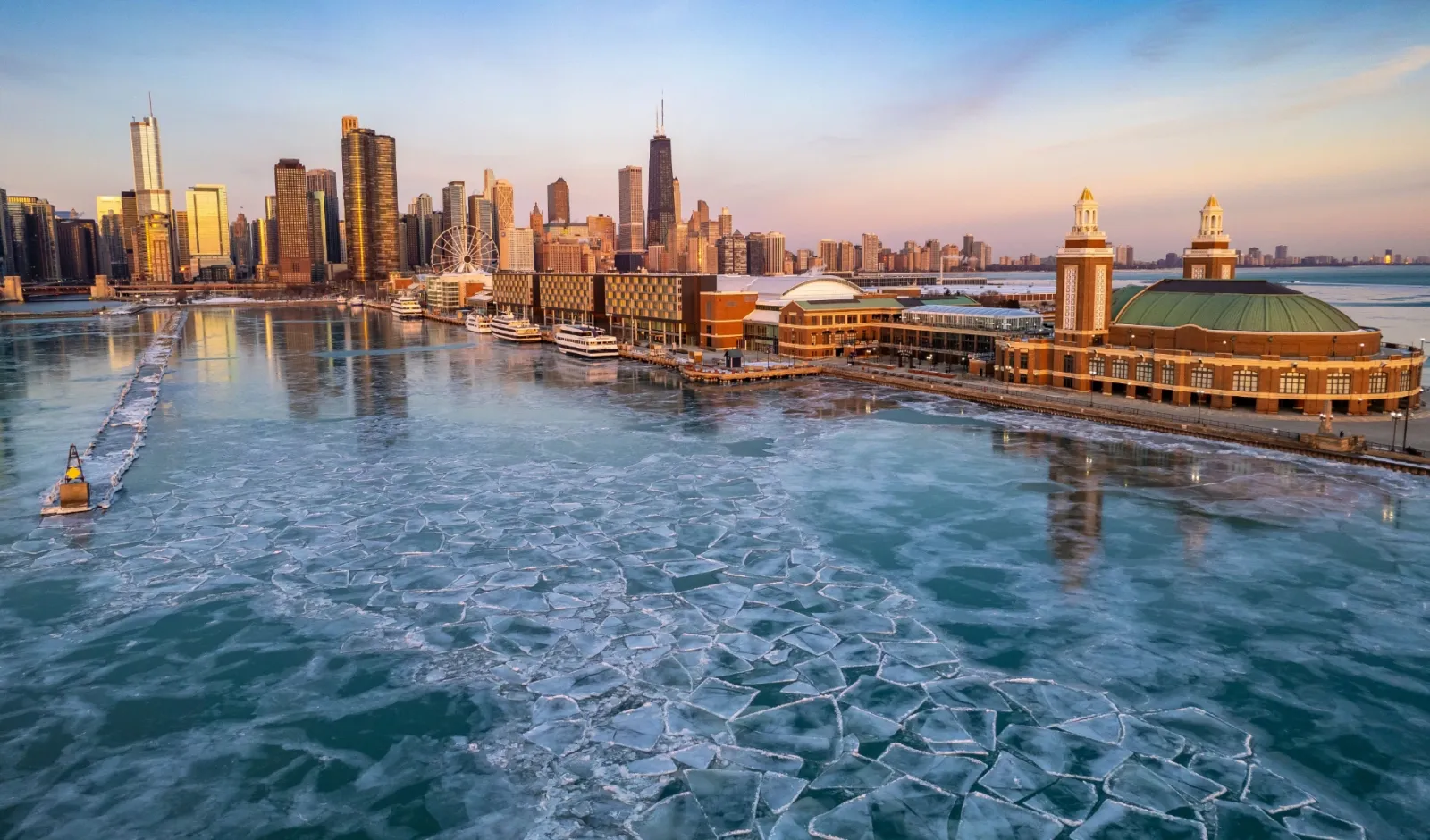 Visione aerea dello skyline di chicago all'alba con una vista sul porto e il lago Michigan ghiacciato